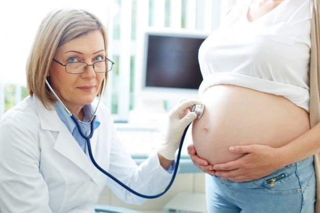 médico obstetra examina grávida