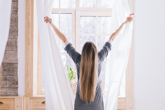 Mulher abrindo as cortinas