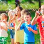 Crianças fazendo bolhas de sabão
