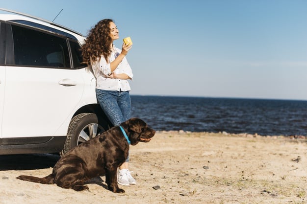 mulher com cachorro na praia