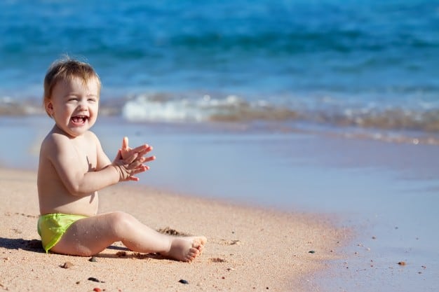bebê fofo na areia