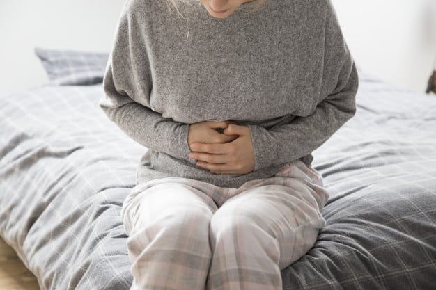 Mulher com dor sofrendo de refluxo gastroesofágico